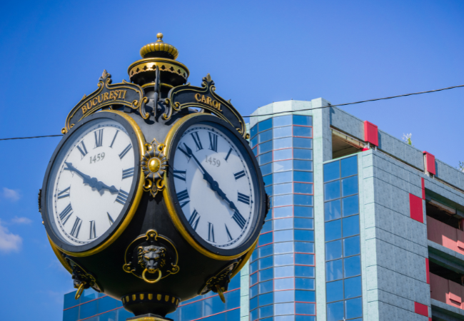 storico orologio di Bucharest di fronte a una costruzione moderna