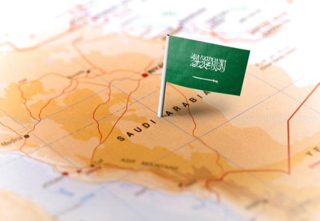 Immagine di una bandiera dell'Arabia Saudita in corrispondenza della regione su una mappa.
