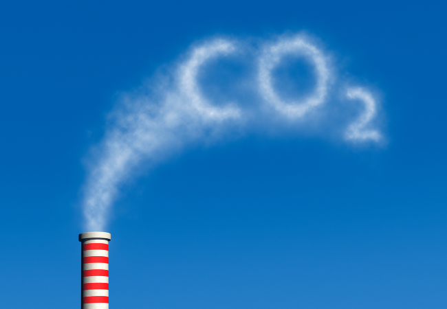 Immagine di una ciminiera il cui fumo forma la scrito "CO2".