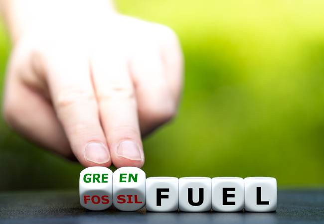 immagine di una mano che gira dei dadi e cambia l'espressione "green fuel" in "fossil fuel"