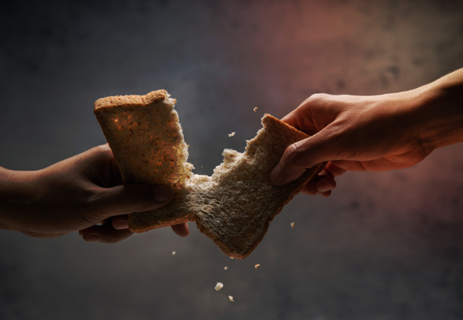 Immagine che mostra due mani che strappano un pezzo di pane.