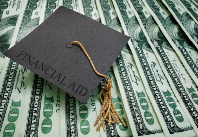 Immagine che mostra delle banconote e un cappellino di laurea con scritto "FINANCIAL AID"