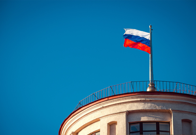 Fotografia di una bandiera russo davanti a un cielo azzurro.