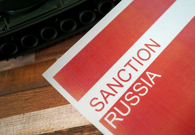 Immagine che mostra un foglio rosso con sopra scritto "SANCTION RUSSIA".