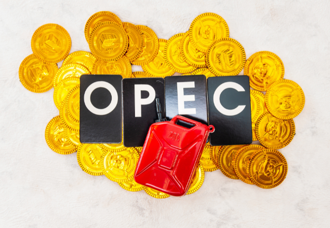 Immagine di una tanica di benzina con dentro dei tasselli con scritto OPEC e delle monete d'oro.