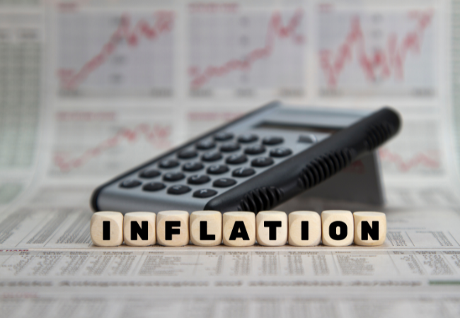 immagine di parola "inflazione" e calcolatrice su un giornale con grafici