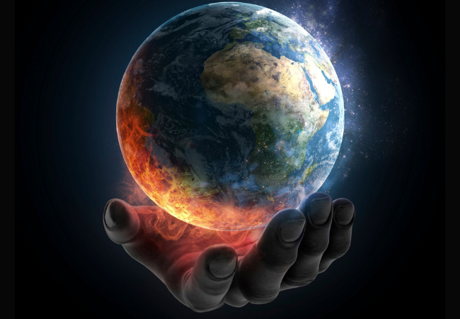 immagine di mano che sostiene il globo terrestre che sta prendendo fuoco