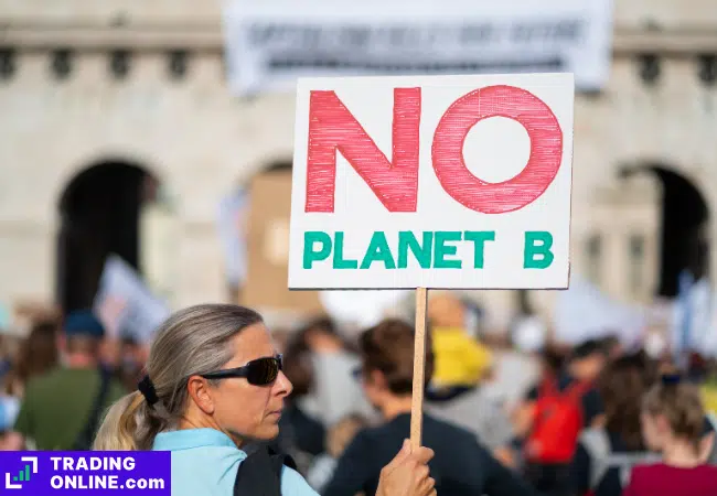 foto di un'attivista con un cartello contro il cambiamento climatico
