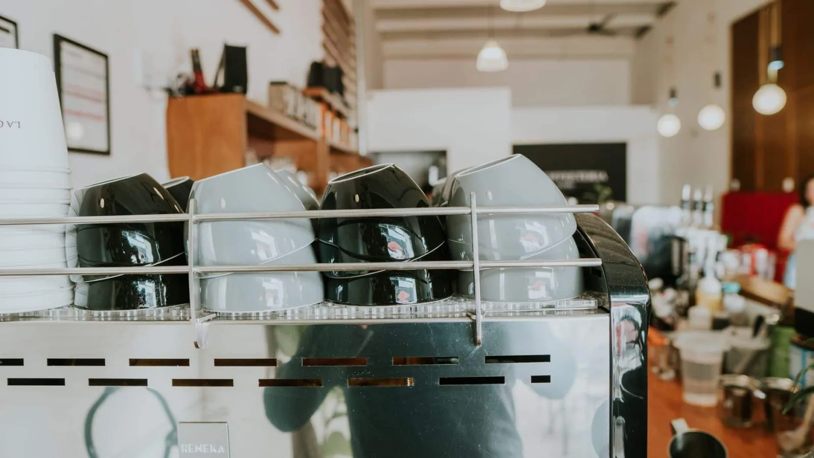 Close-up of stacked ceramic cups on a coffee machine in a trendy café.