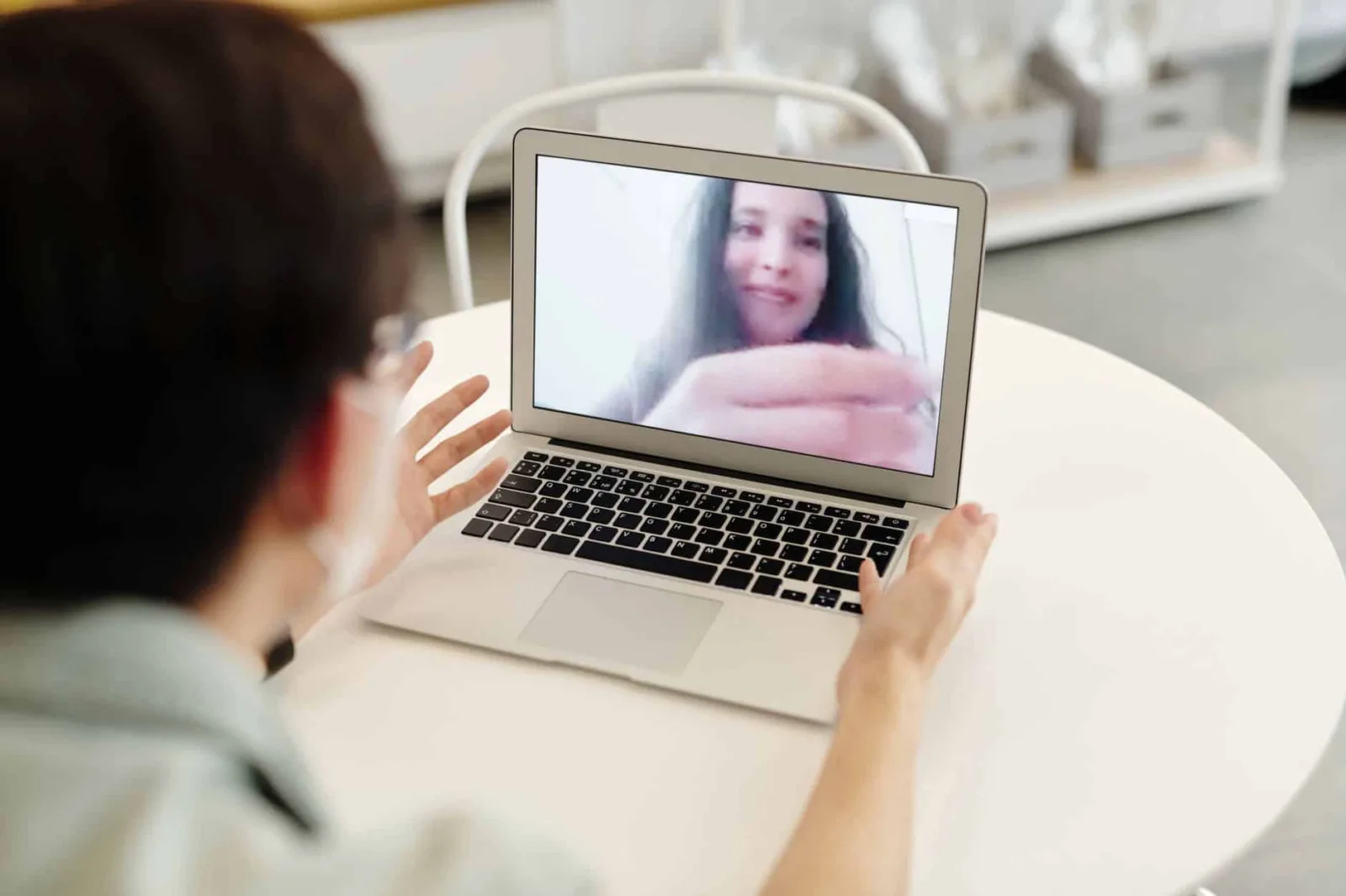A person having a video call on a laptop, indoors, showcasing digital communication.